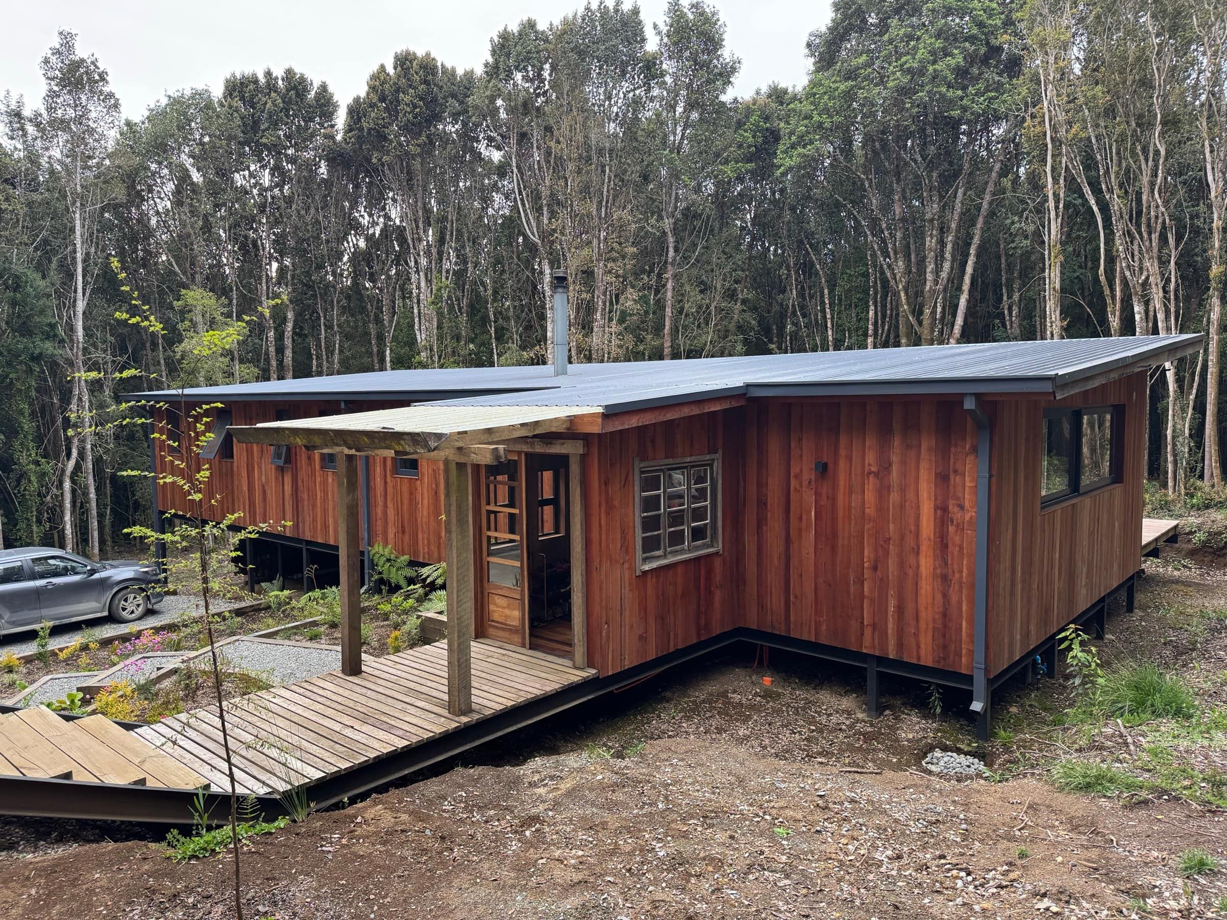 La casa de madera nativa entre los árboles del bosque