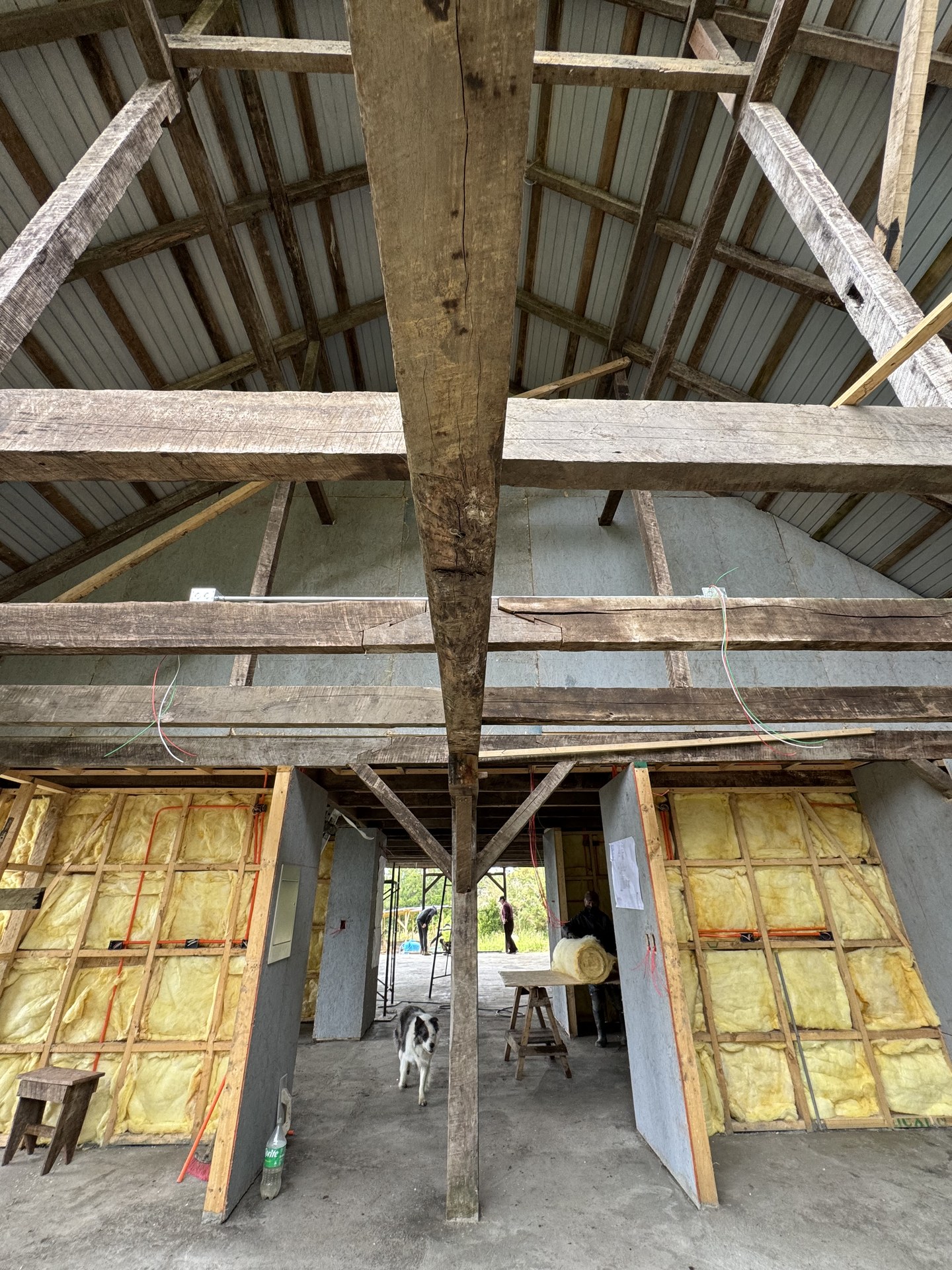 Interior en etapa final de construcción — estructura centenaria y materiales nuevos conviviendo